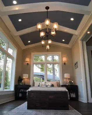 Bedroom with tray ceiling, a bold statement chandelier, large windows, and modern decor.